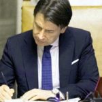 Giuseppe Conte mentre firma un decreto